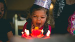 A birthday girl blowing out candles on a cake
