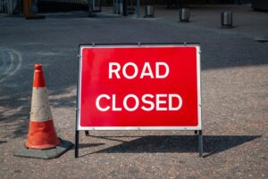 Red,Road,Closed,Sign,In,The,Street,With,A,Traffic Red,Road,Closed,Sign,In,The,Street,With,A,Traffic